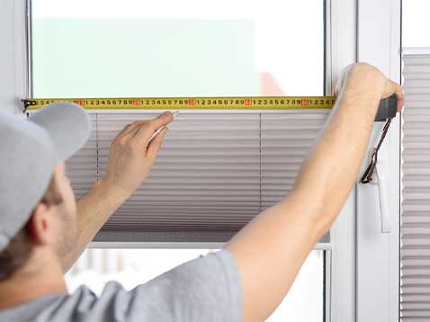 Man taking window measurements with a tape measure